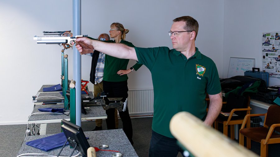 Sportschütze mit Luftpistole am Druckluftstand