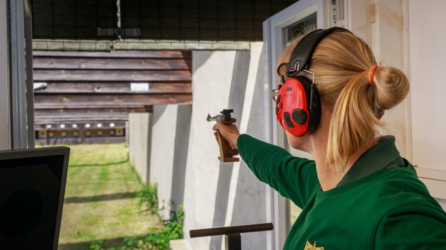 Sportschützin mit Kleinkaliberpistole am Schießstand