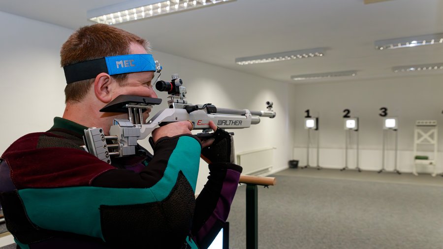 Sportschütze mit Luftgewehr am Druckluftstand